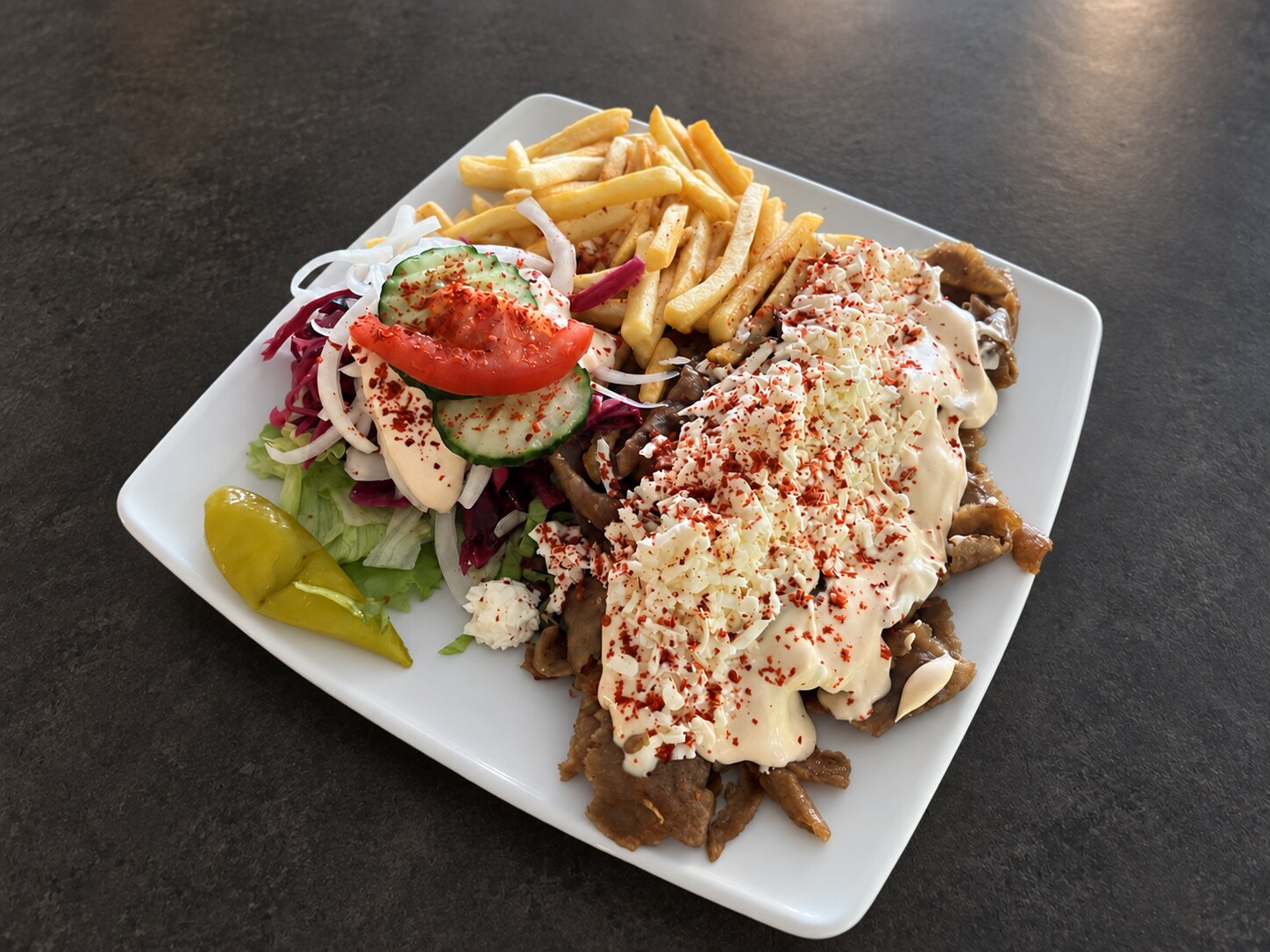 Dönerteller mit Fleisch, Sauce, Salat und Pommes bei Kürshat’s